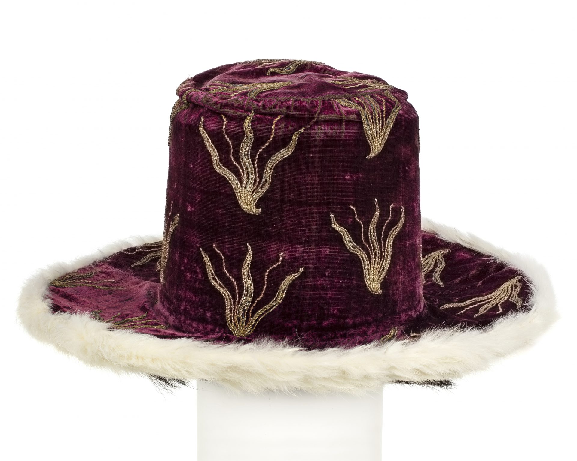 A purple hat of velvet with embroidered flames in gold.