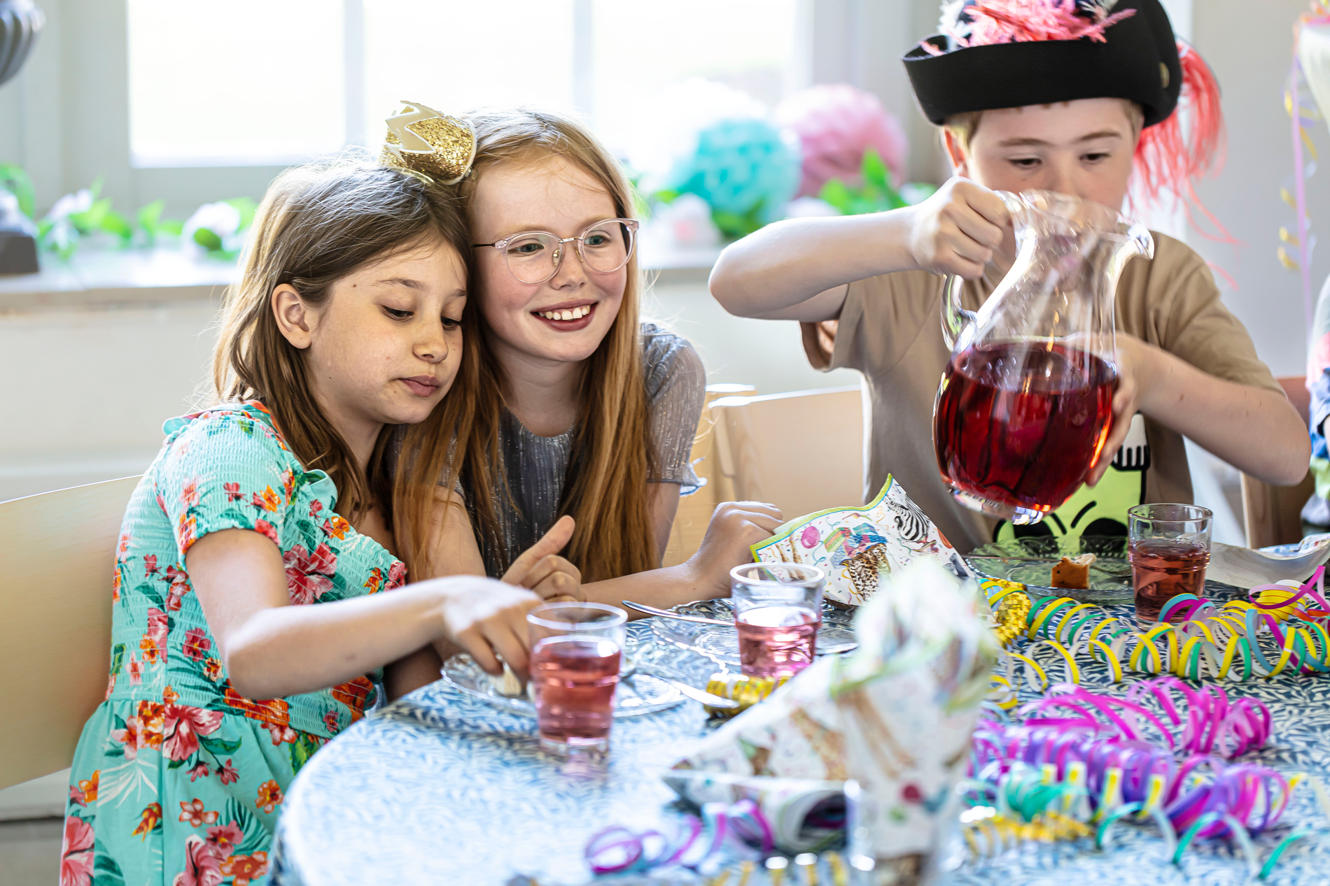 Three children eating a cake.