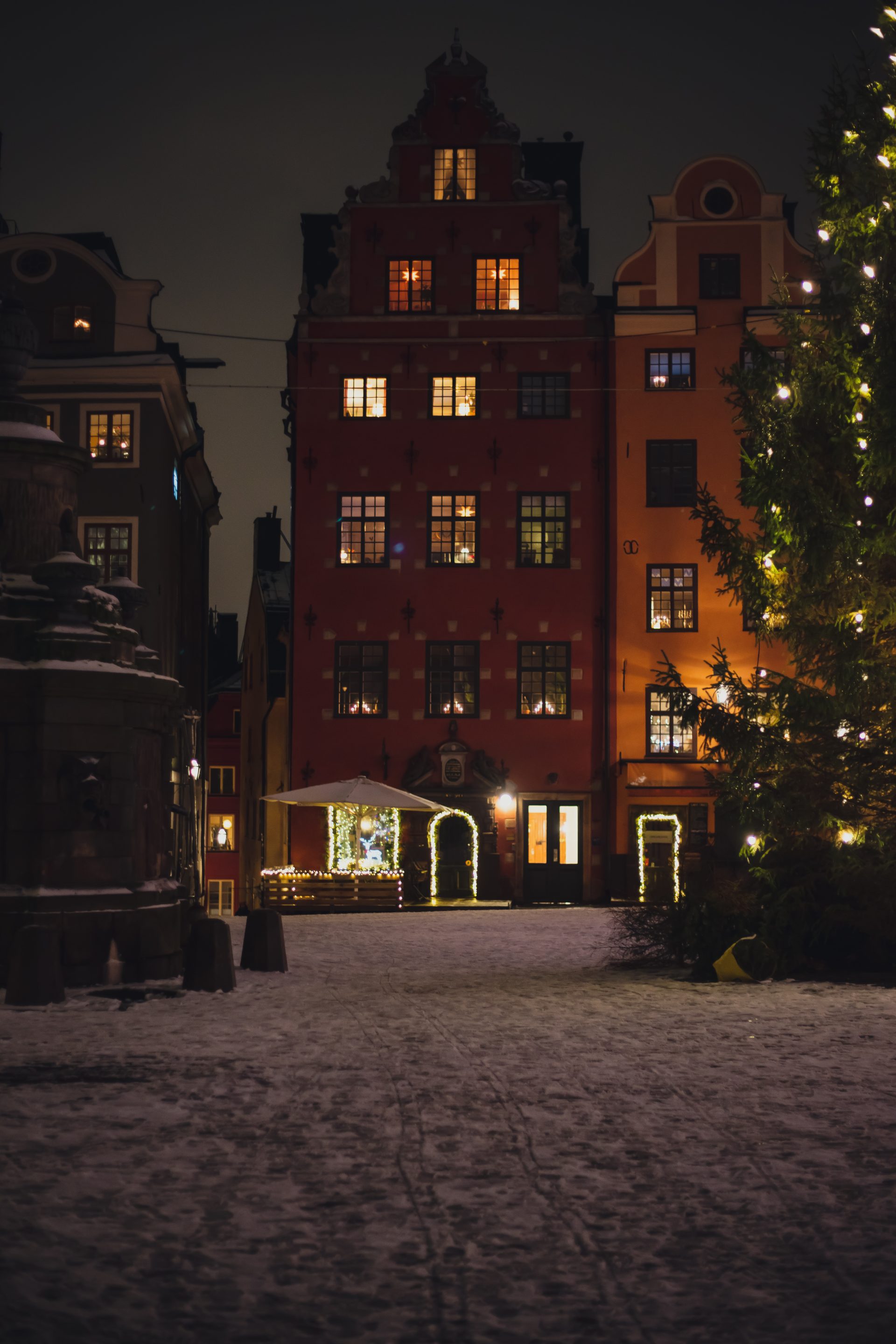 Två byggnader i gamla stan och en stor julgran framför