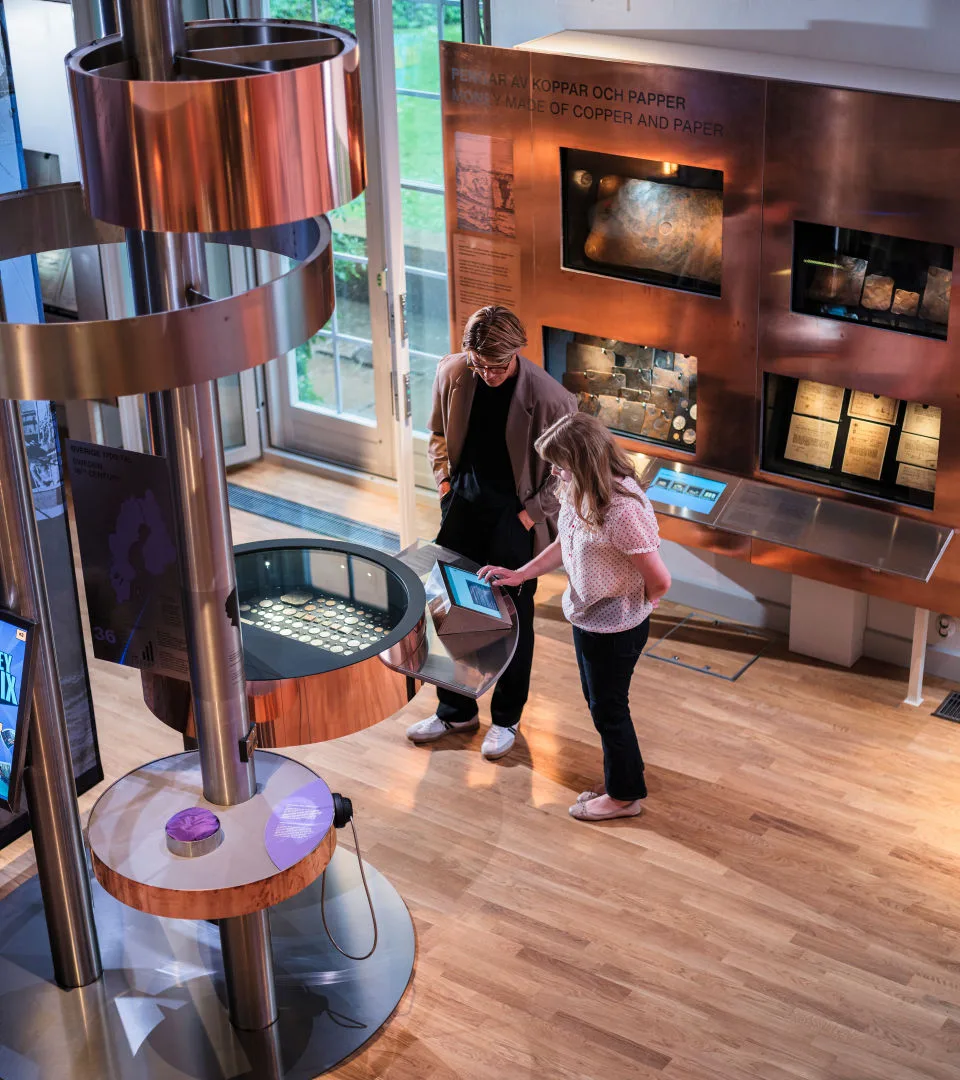 People looking at coins in an exhibition