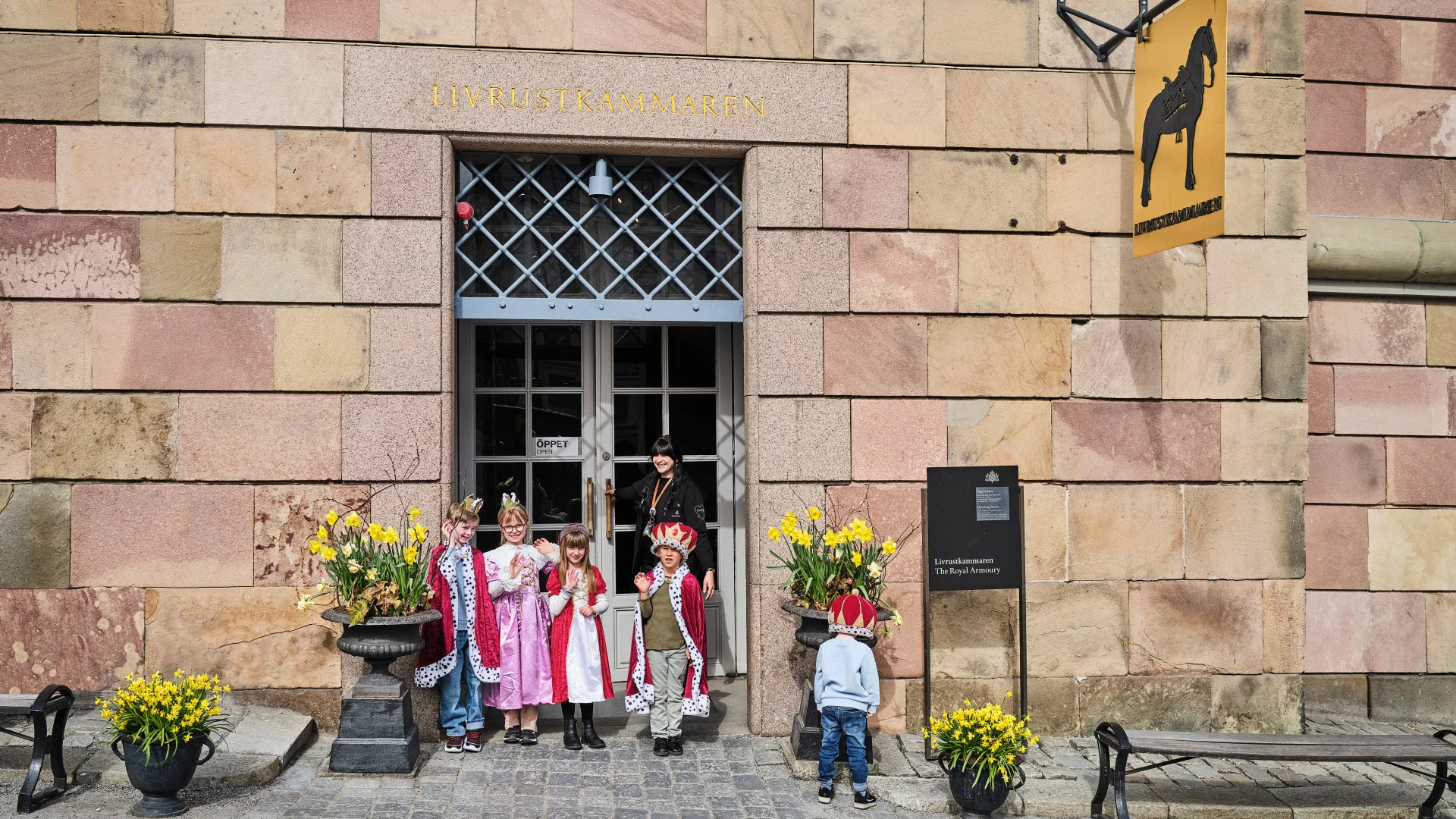 Barn utklädda till kungar och drottningar med personal vid Livrustkammarens ingång