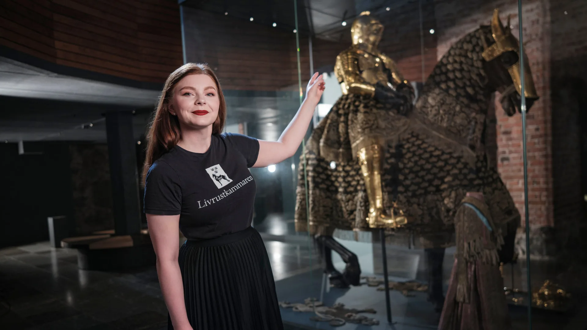 Museipedagog pekar på en riddare på en uppstoppad häst