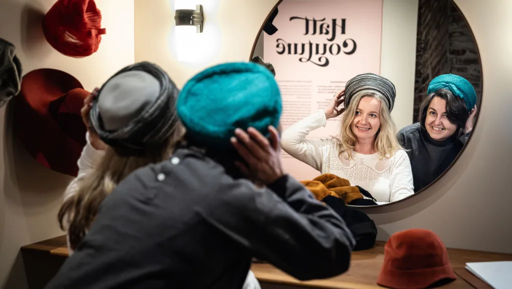 Visitors try on hats in the exhibition.
